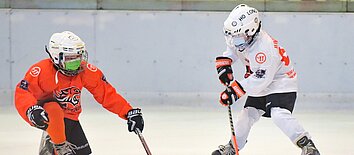 Two ice hockey players learning to skate
