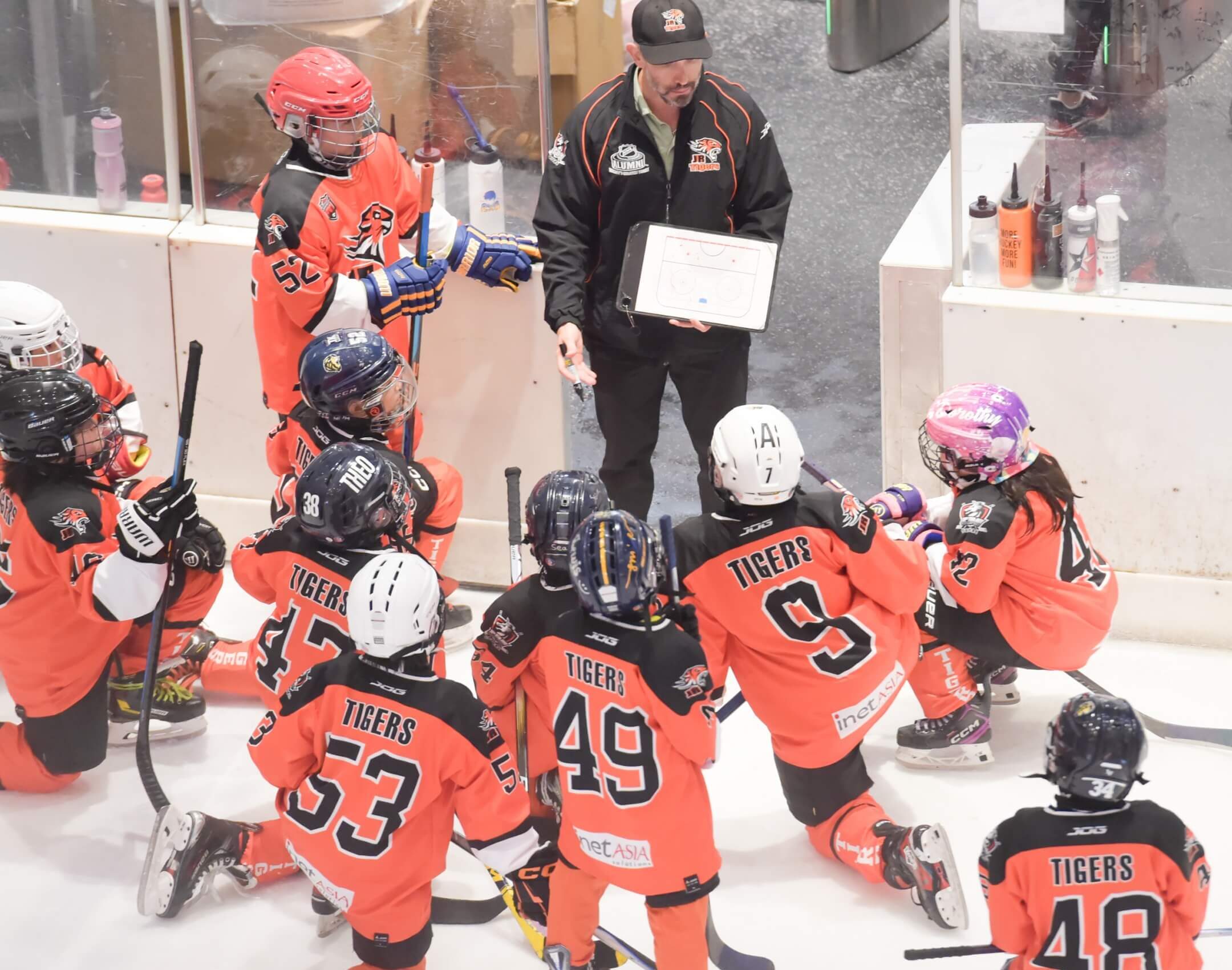A coach giving a strategy for the young ice hockey team