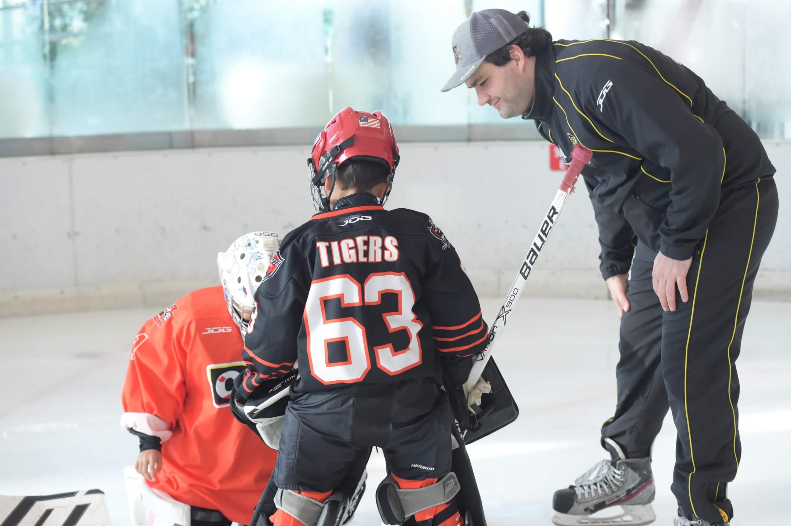 An Ice hockey coach carefully checking the kids
